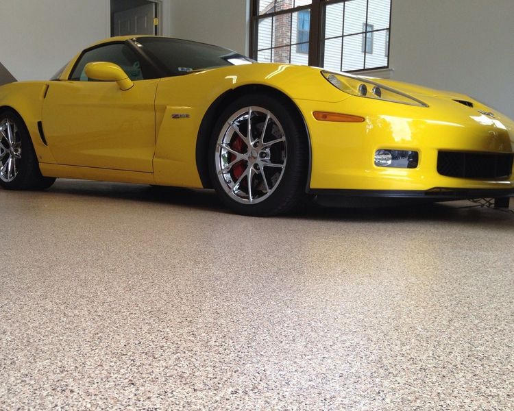 A yellow sports car is parked in a garage