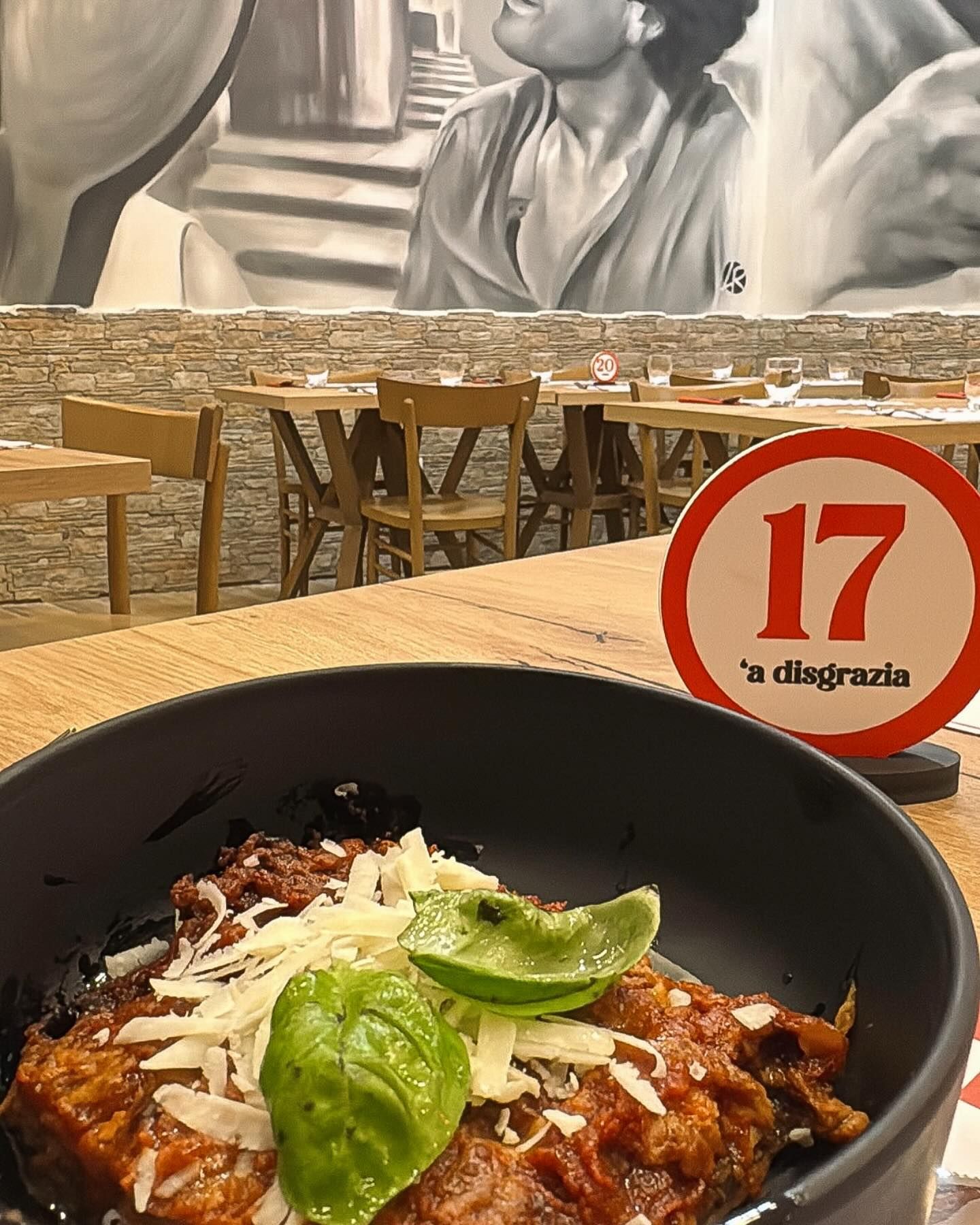 Una persona tiene in mano una ciotola di cibo davanti a un murale di una donna