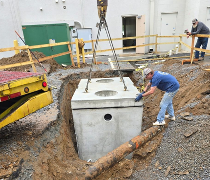 A worker in blue hard hat tightens pipes with a wrench, wearing gloves and safety glasses. A worker in blue hard hat tightens pipes with a wrench, wearing gloves and safety glasses.