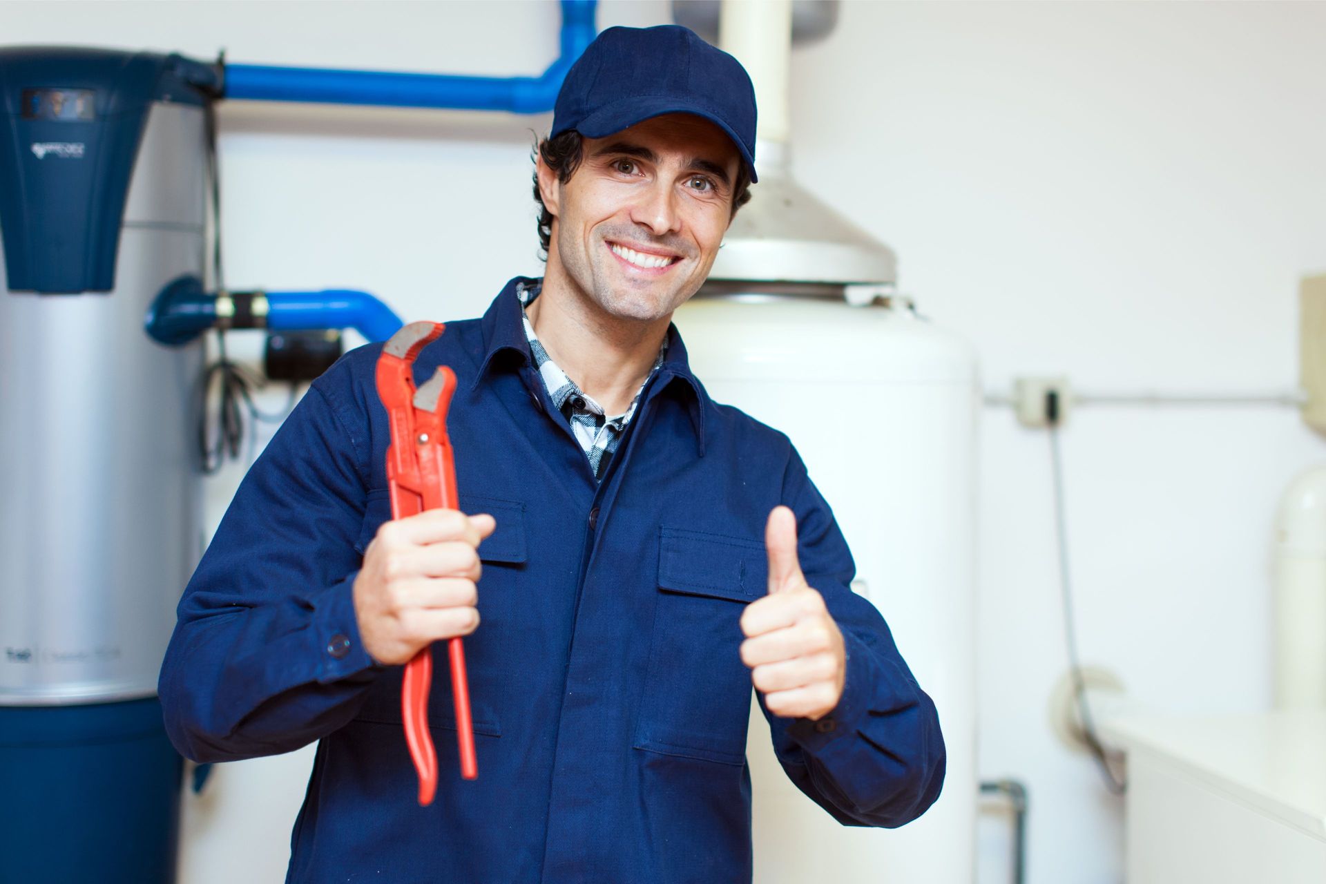 Plumber working under a kitchen sink, tools beside him on the floor. Plumber working under a kitchen sink, tools beside him on the floor.