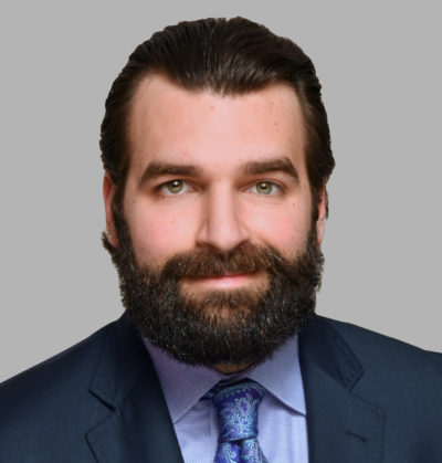 A man with a beard is wearing a suit and tie.
