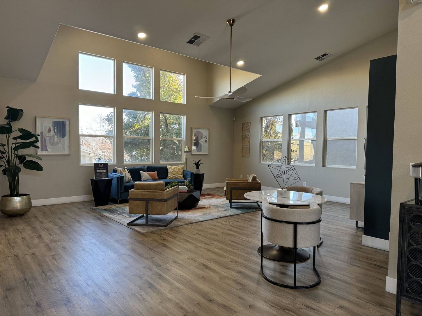 Spacious living room with high ceilings, large windows, and modern furniture.