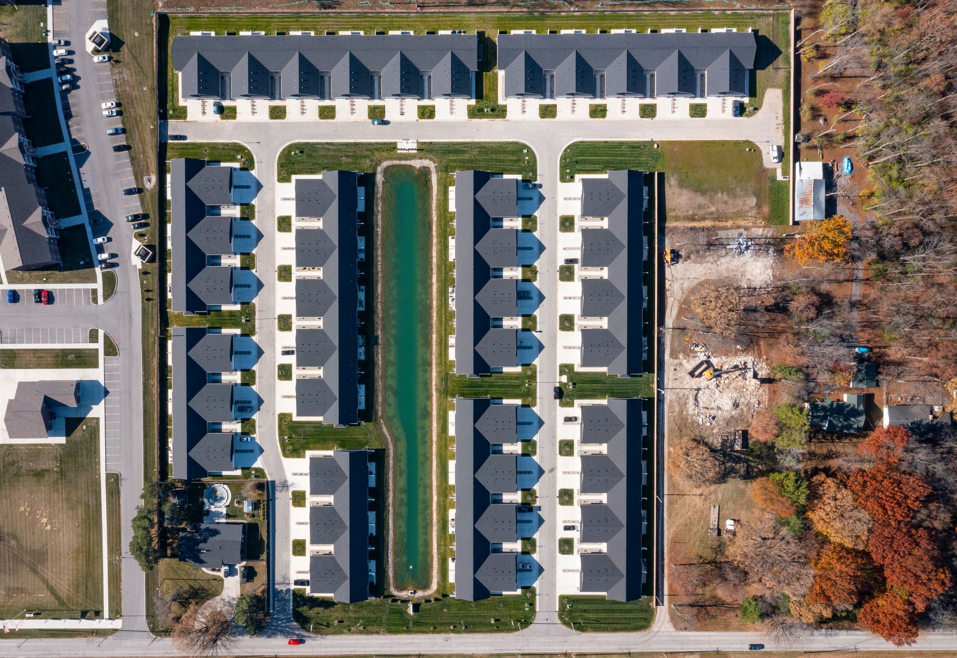 Photo looking straight down upon the community from high above in the sky, showing rows of houses and a small body of water
