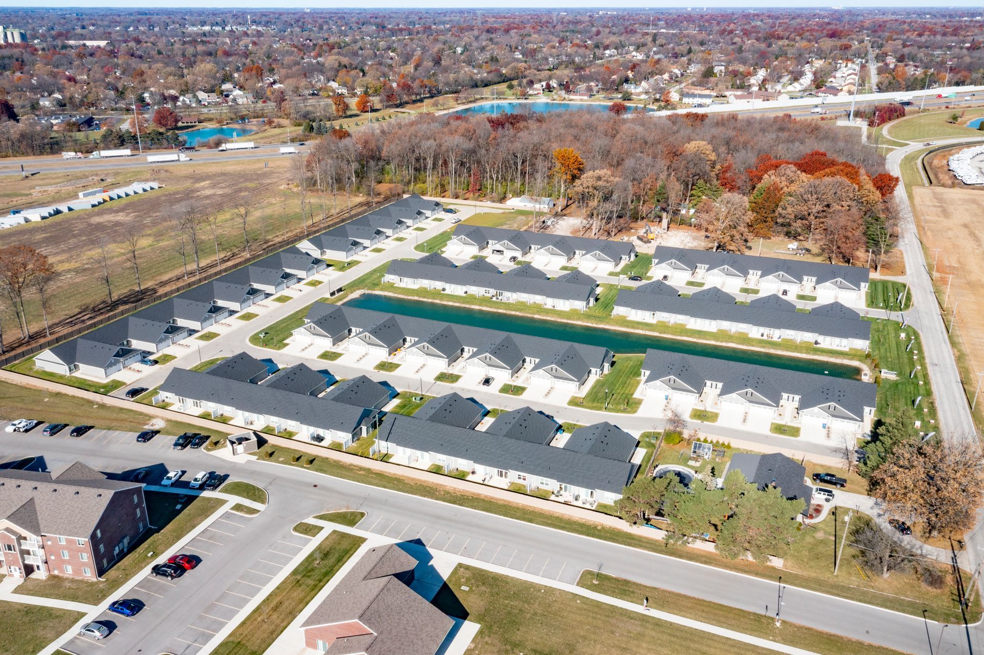 Photo of the community seen from the sky, showing a body of water behind the homes in the center