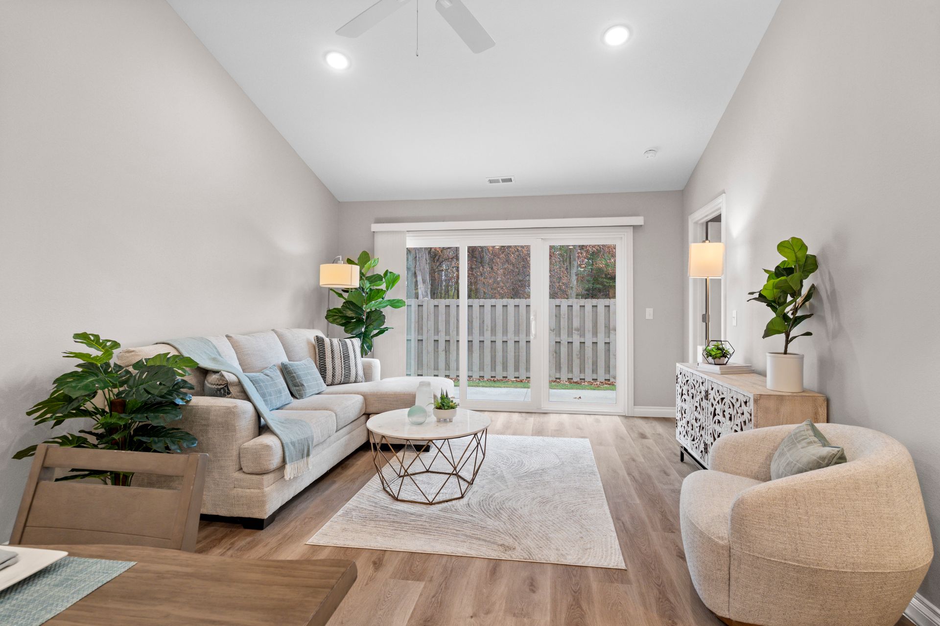 Photo of a living room with a long couch that has an extension part on it, as well as various other furniture around