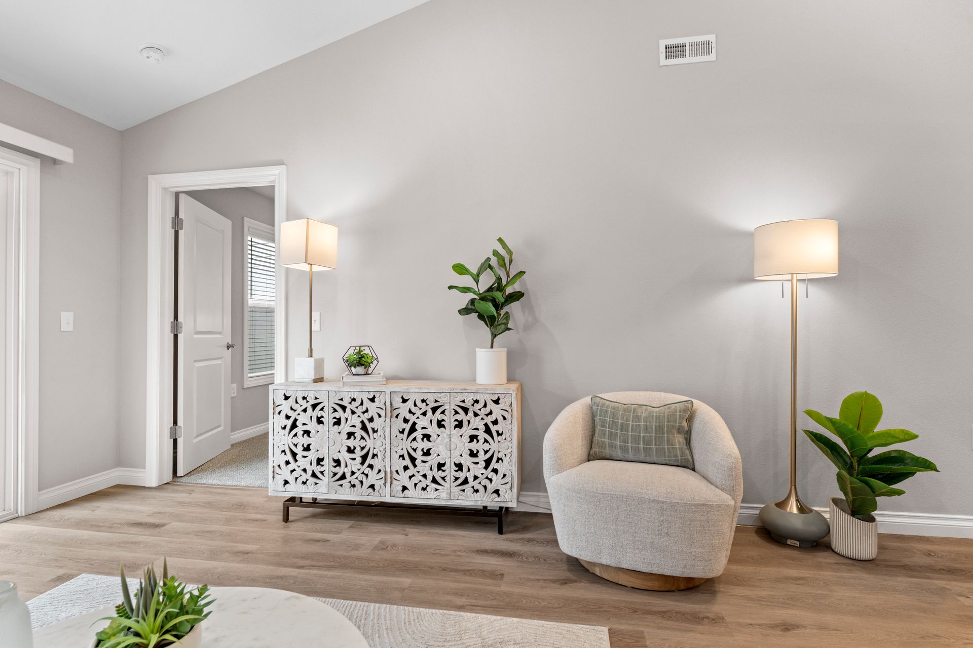 Photo of a chair with a side table and a couple of lamps