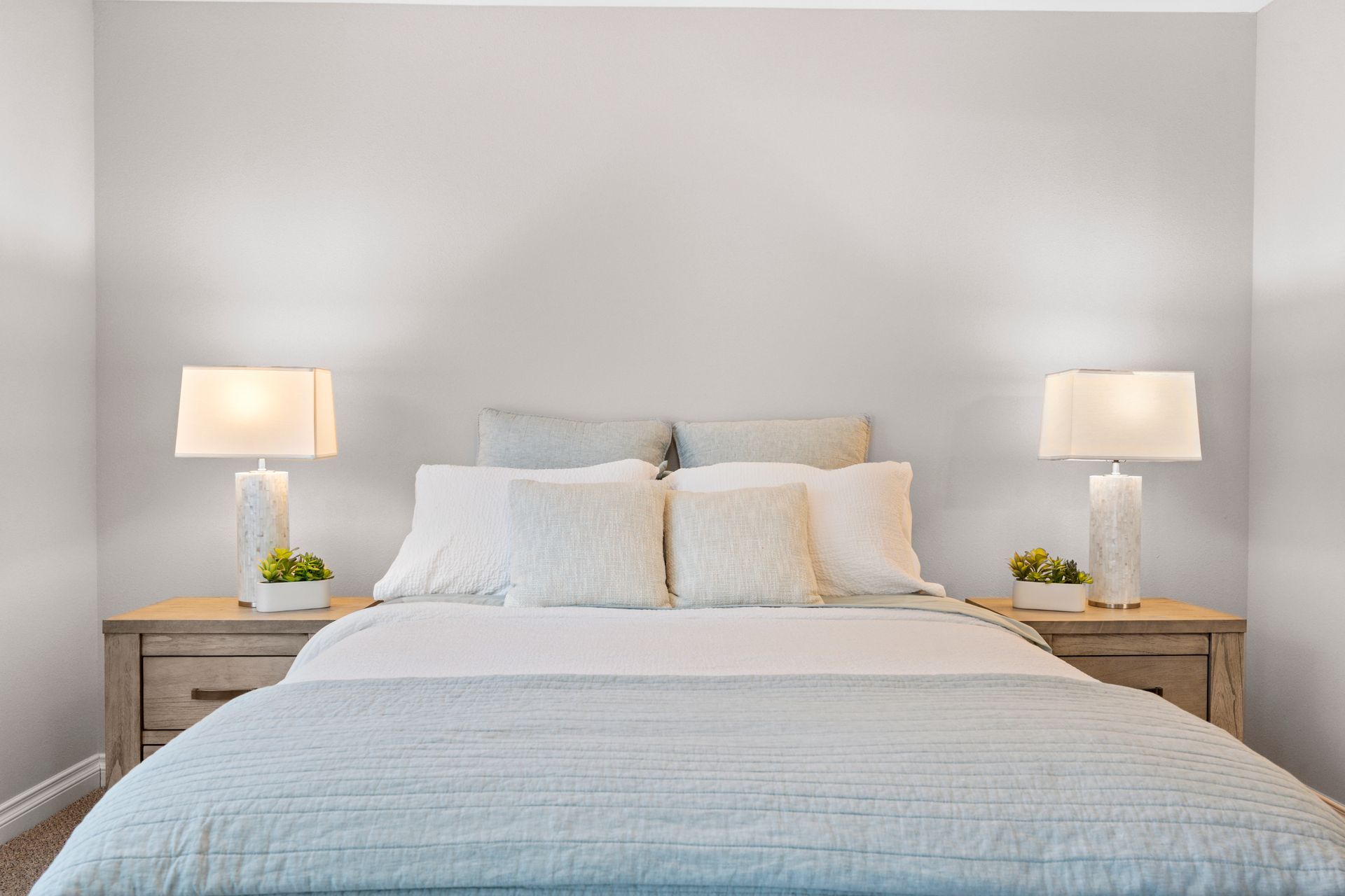 Photo of a bed with a night stand on each side