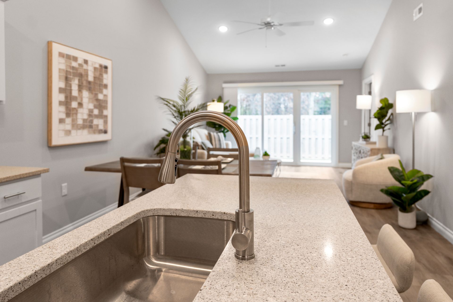 Closeup photo of the kitchen sink on an island and a barstool area