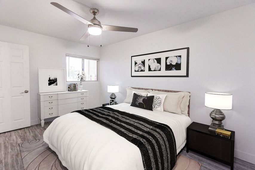 Bedroom with bed, dresser, nightstands, art, ceiling fan, and a window.