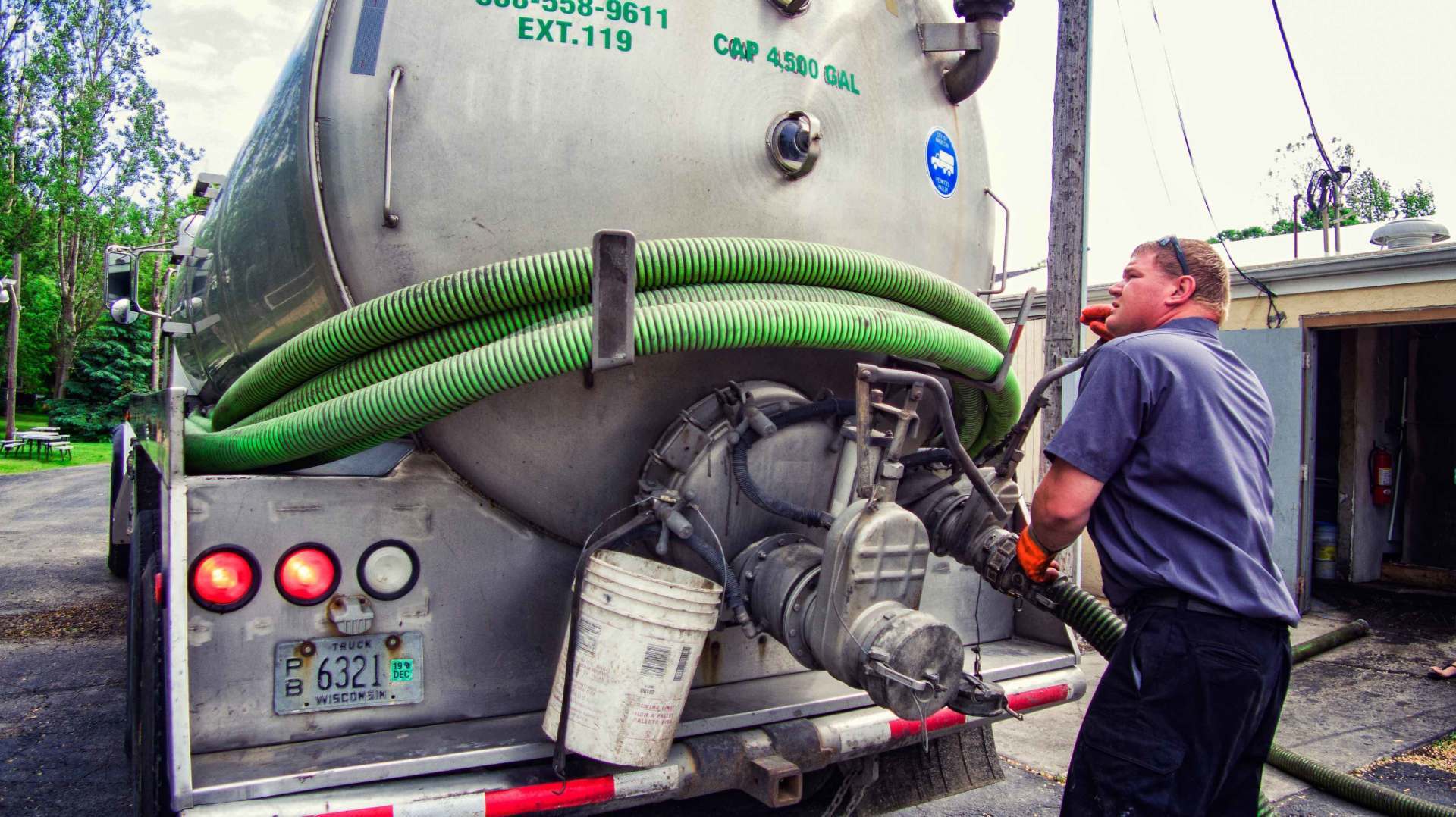 Worker Prepares the Hose on Truck — Clyman, WI — United Septic & Drain Services Inc