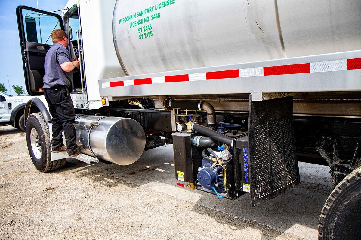 Man Climbing to Enter the Truck — Clyman, WI — United Septic & Drain Services Inc