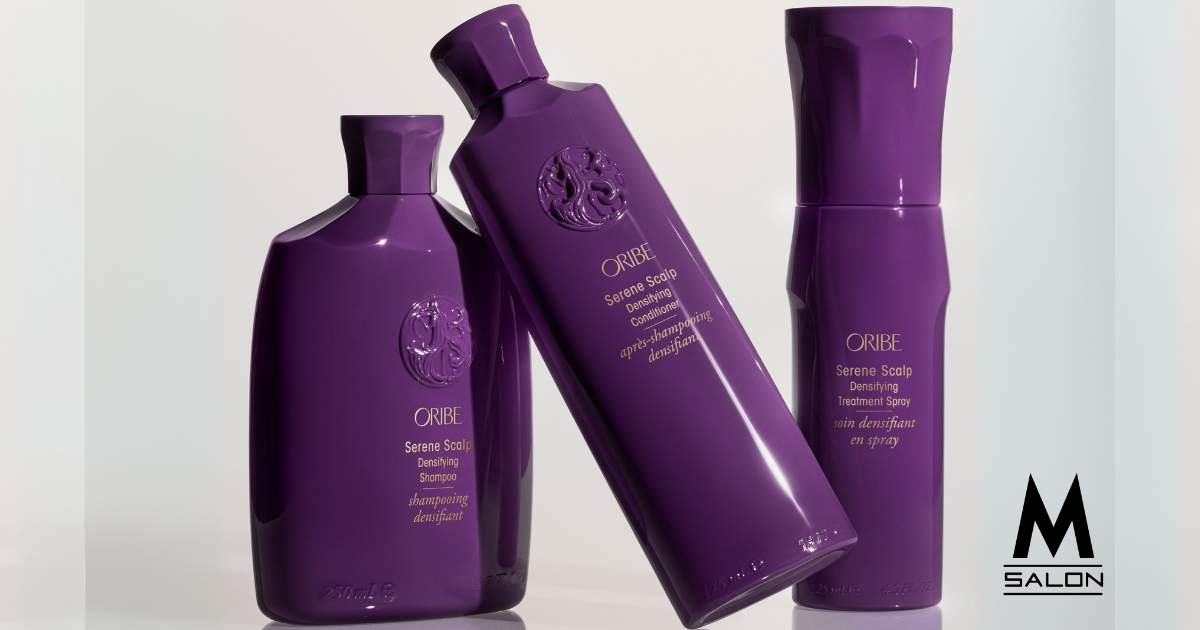 Three purple bottles of hair products are sitting next to each other on a table.