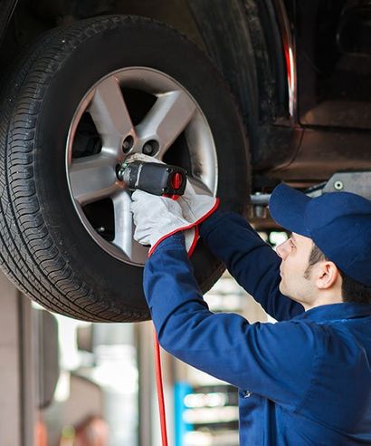 Auto Repair Services — Man Removing Car Tire in South Bound Brook, NJ
