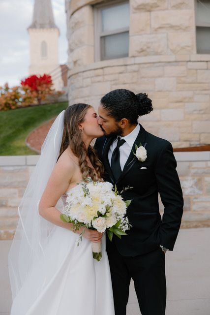 A person is holding a bouquet of pink and blue flowers