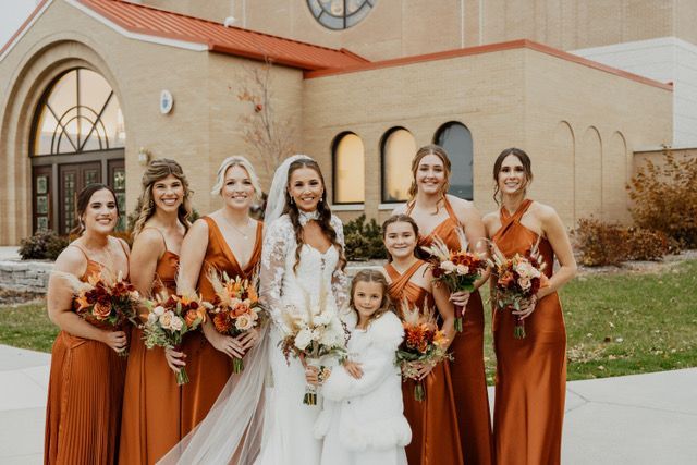 A vase filled with pink roses and blue berries