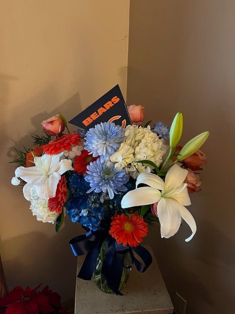 A vase of flowers with a card that says bears on it