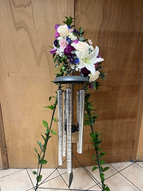 A wind chime with flowers on top of it