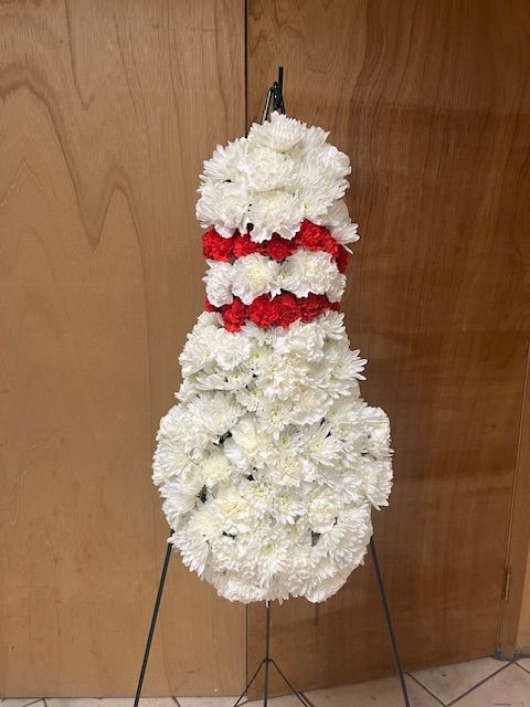 A snowman made of white flowers and red roses