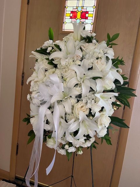 A bunch of white flowers on a stand in front of a door