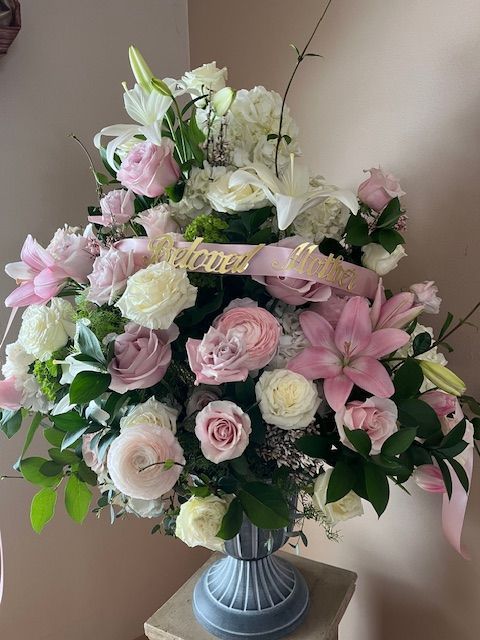 A vase filled with pink and white flowers is sitting on a table.