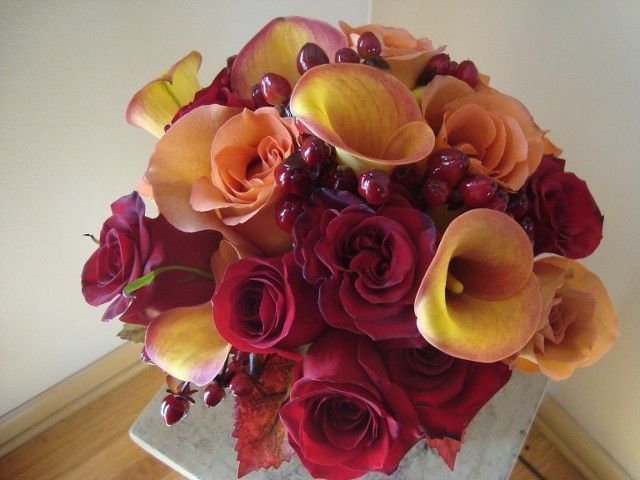 A bouquet of red roses and yellow calla lilies