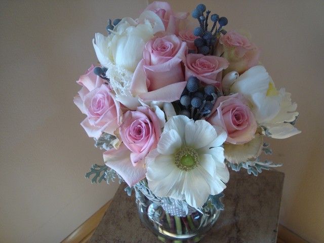 A vase filled with pink roses and white flowers