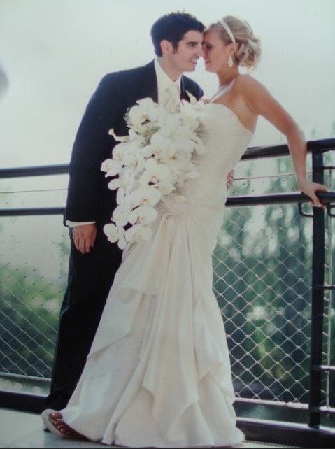 A bride and groom standing next to each other on a balcony