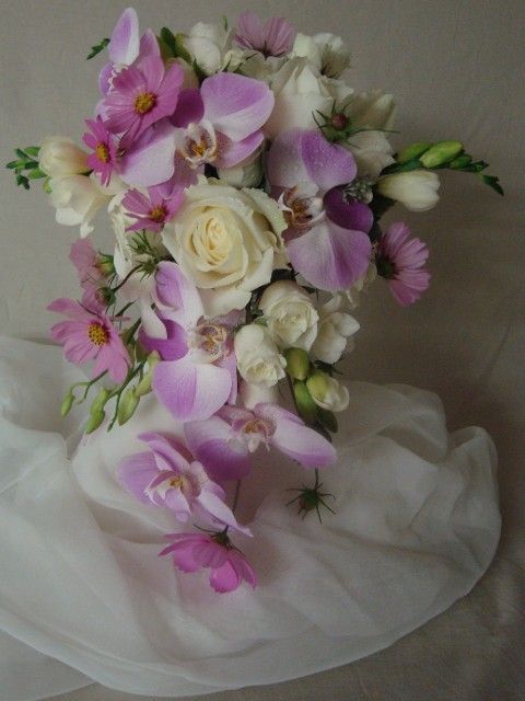 A bouquet of pink and white flowers on a white cloth
