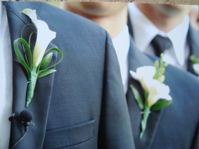 Two men in suits with white flowers on their jackets