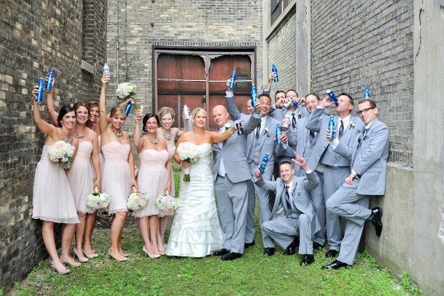 A bride and groom are posing for a picture with their wedding party.