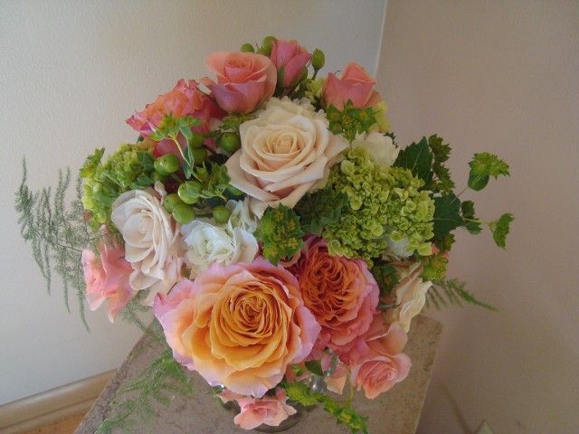 A bouquet of flowers is sitting on a wooden table.