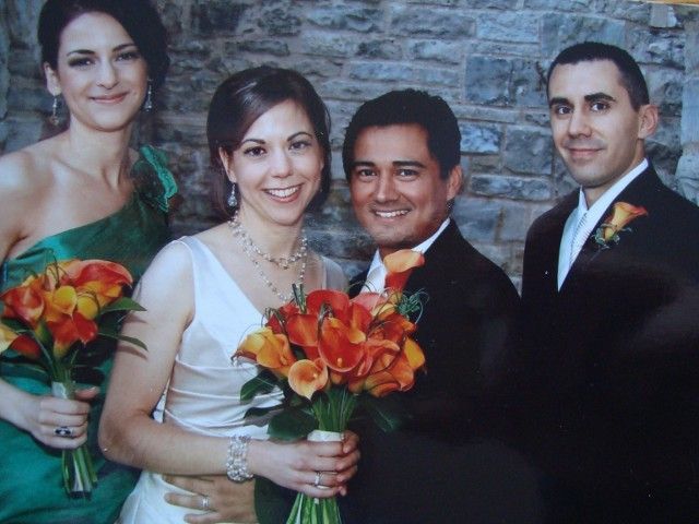 The bride and groom are posing for a picture with their bridesmaids