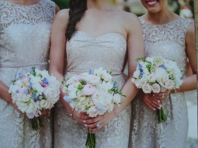 Three bridesmaids are holding bouquets of white flowers