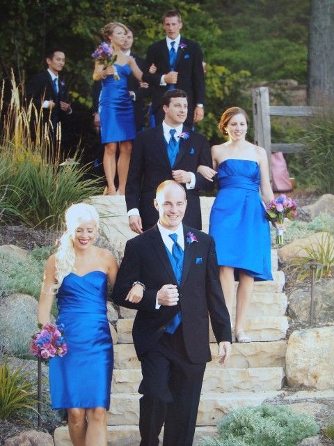 The bride and groom are walking down the stairs with their wedding party