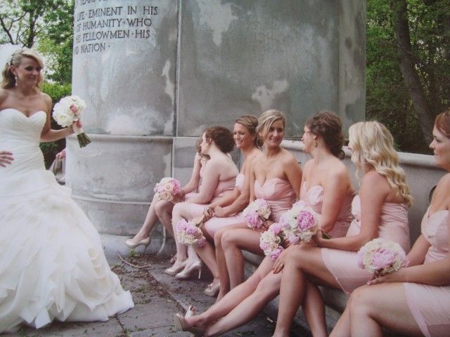 A bride and her bridesmaids are sitting on a bench