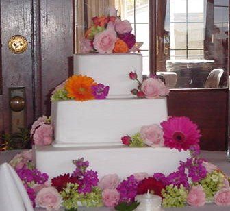 A wedding cake decorated with pink and purple flowers