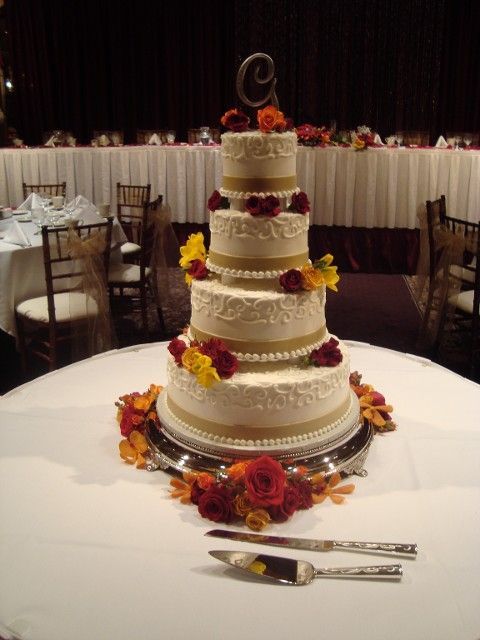A wedding cake with the letter c on top of it