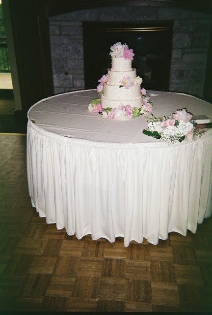 A wedding cake on a table with a white table cloth