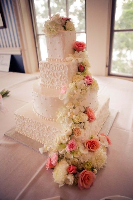 A wedding cake with flowers on it is on a table.