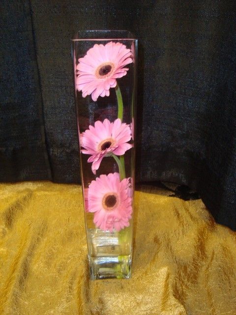 A clear vase with pink flowers in it