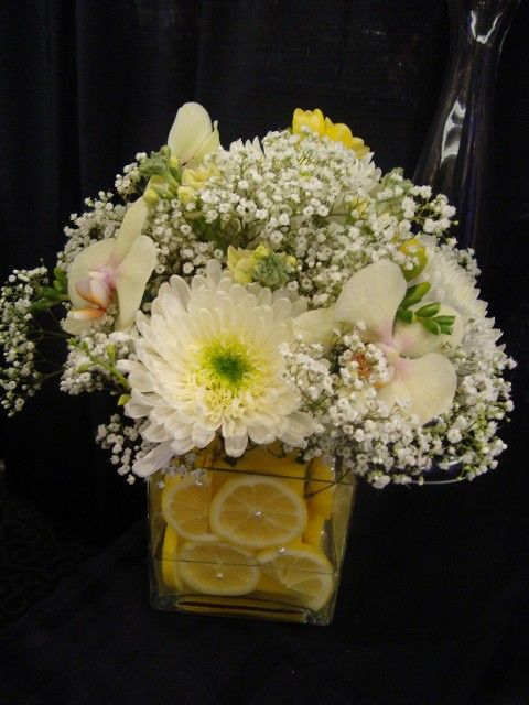 A vase filled with white flowers and lemon slices