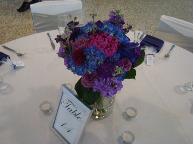 A table with purple and blue flowers and a table number