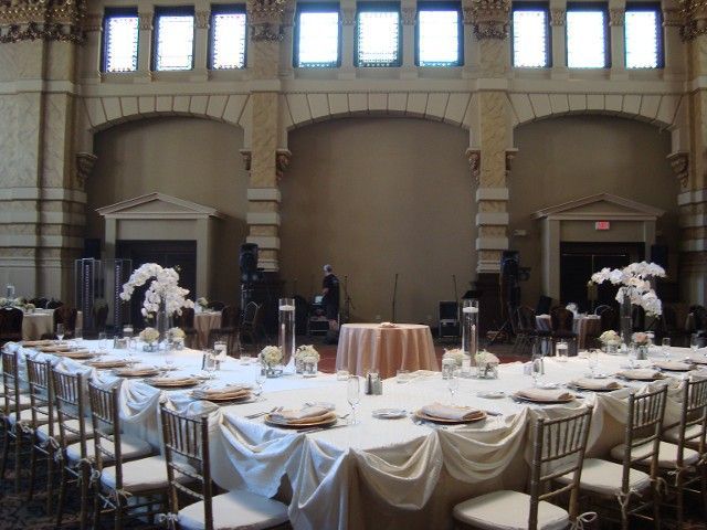 A large room with tables and chairs set up for a wedding reception