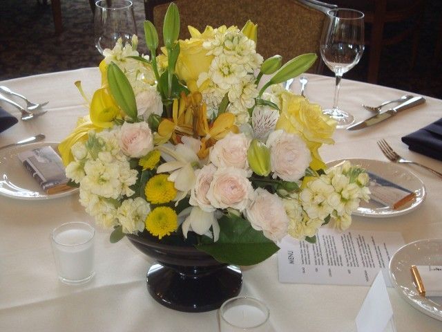 A table setting with a vase of flowers on it