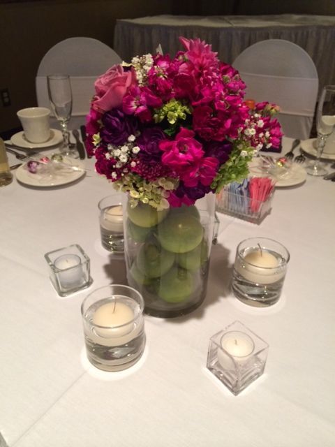 A table with a vase of flowers and candles on it