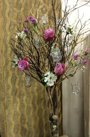 A vase filled with purple and white flowers and branches
