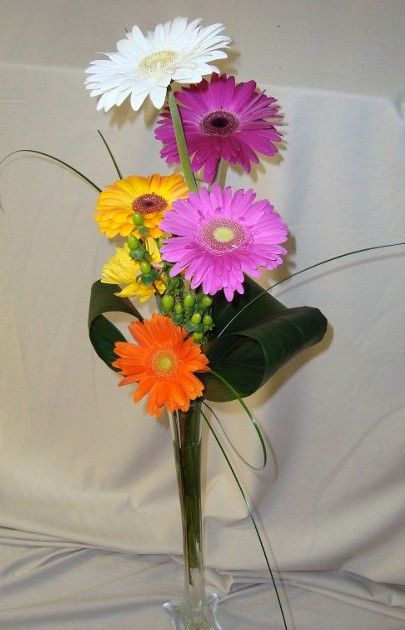 A vase filled with different colored flowers on a table