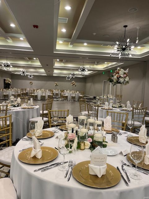 A large room with tables and chairs set up for a wedding reception.