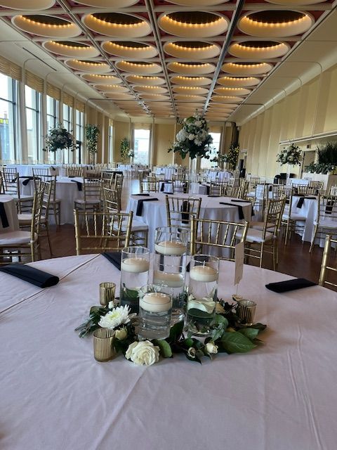 A large room with tables and chairs set up for a wedding reception.