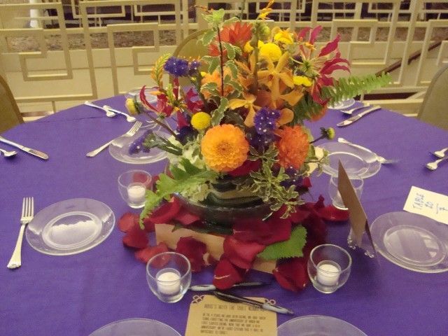 A purple table with a centerpiece of flowers and candles